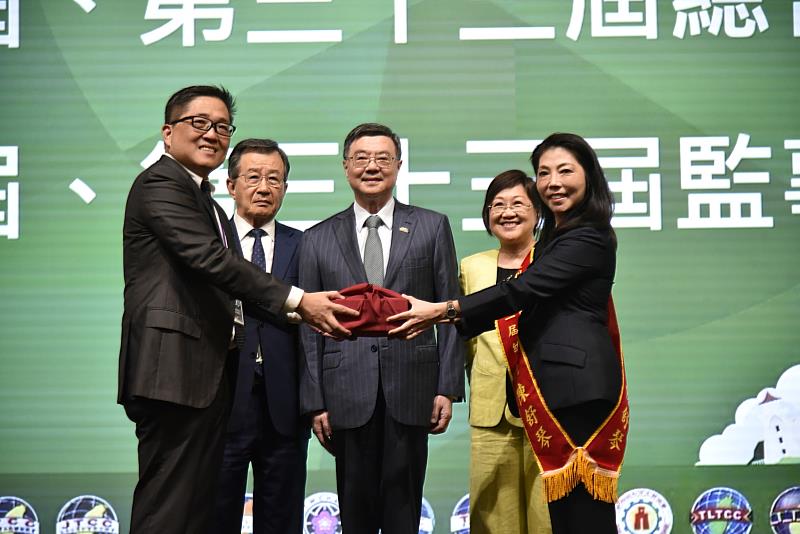 由行政院院長卓榮泰(中)、僑務委員會委員長徐佳青(右2) 見證、世界臺灣商會聯合總會總會長吳光宜(左2)監交，亞總第32屆總會長林凱民(左1)交接印信予第33屆總會長陳舒琴(右1)