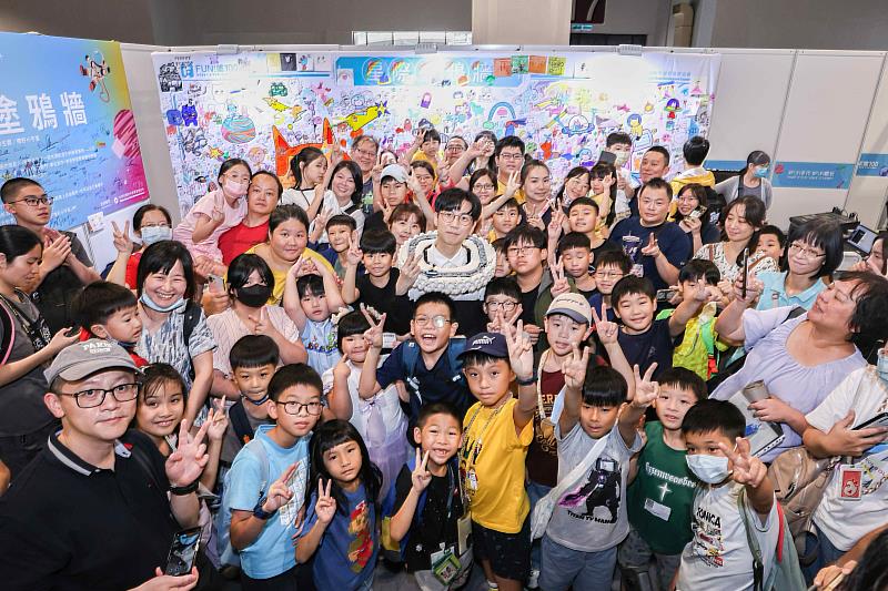 積木國王大黑白在色彩繽紛的星際塗鴉牆前與民眾合影，為「FUN!嗜100」的共創藝術活動畫下精彩句點。(貿協提供)
