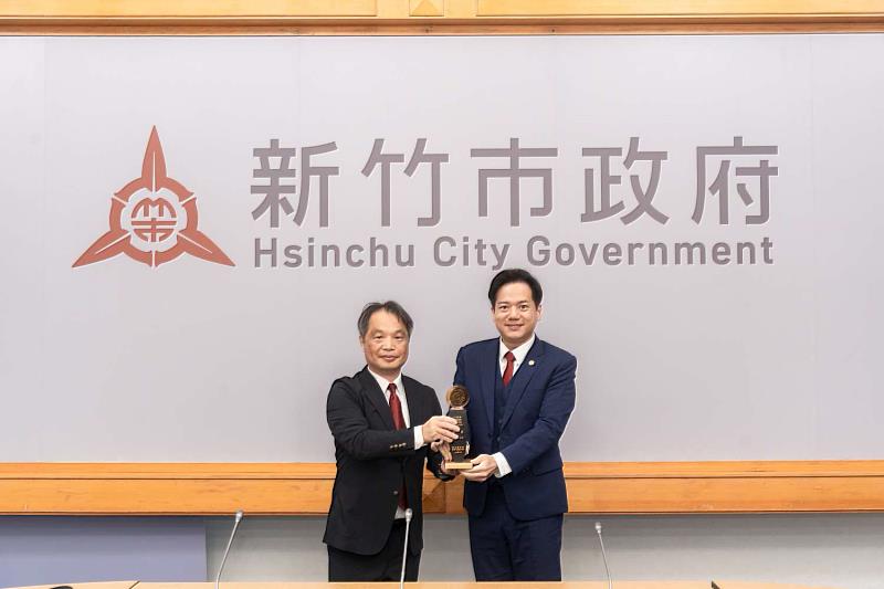 衛生局長陳厚全獻獎予代理市長邱臣遠。