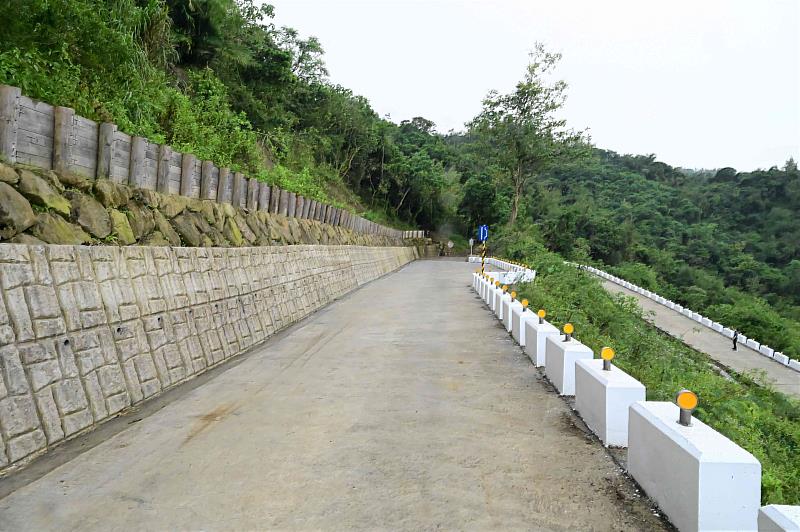 南山林道工程擋土牆上邊坡採用國產材做成木構擋土柵及現地塊石之砌石,並設置塊狀護欄、反光導標及避車道增加行車安全