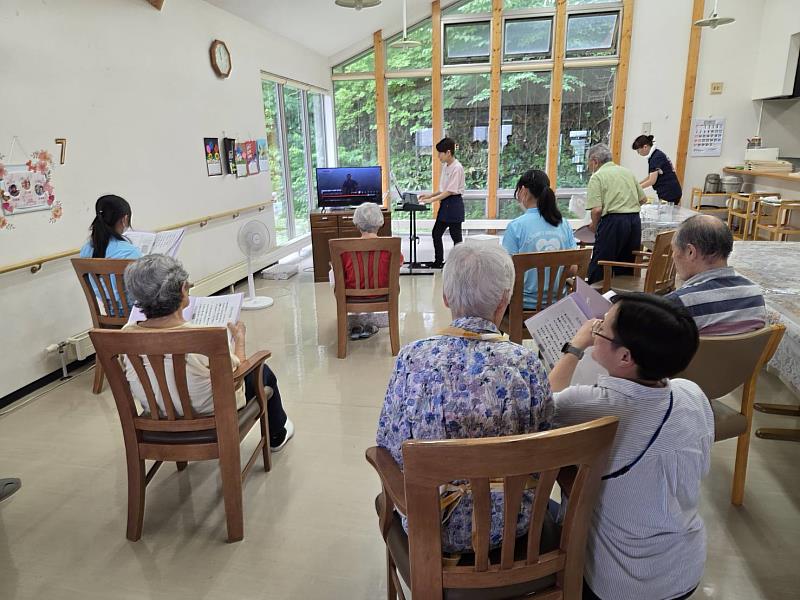 樂齡系學生在「小多機癒暖」協助長者參與團體活動，觀摩並學習日本長照機構的日常照護與互動方式。
