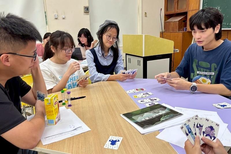 營隊講師與南大師資生共同討論數學特色桌遊課程,細部調整教案設計以提升學習互動性。