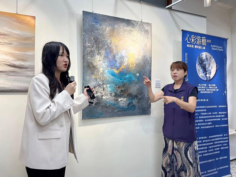 創作者周鈺欣(左)與手語翻譯老師搭配,為聽障朋友導覽介紹畫作