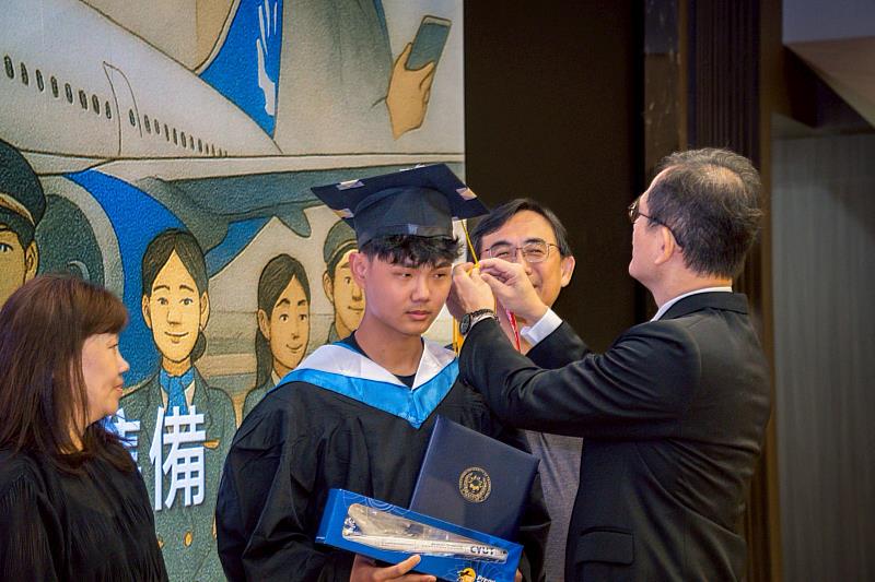 航空學院院長張友信(右)為畢業生撥穗,並移除學士帽上的「飛機飄帶」,期勉飛航系學子勇敢啟航。