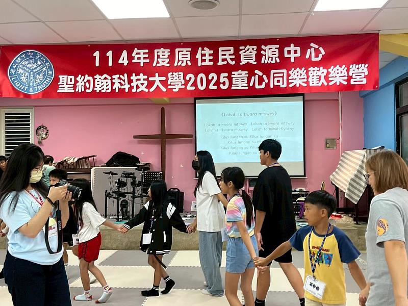 學童們與學生志工開心地跳著圍舞。