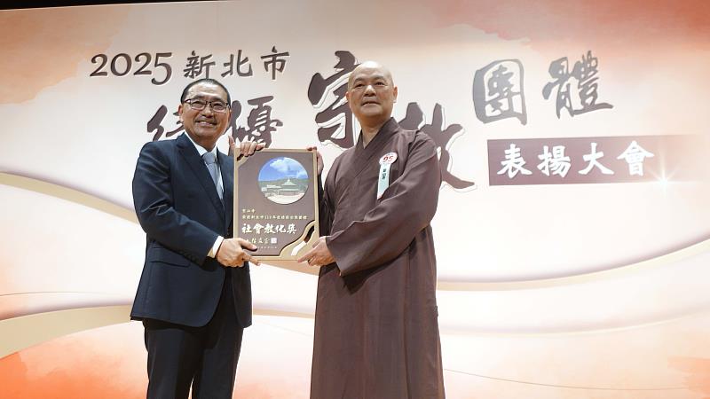 新北市長侯友宜（左）頒獎給聖山寺，由監院懇慧法師（右）代表接受。（圖由靈鷲山佛教教團提供）