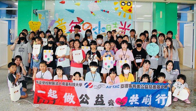 南臺科大幼保系學生會暑假舉辦「童年的小時光」營隊與小學生快樂合影。