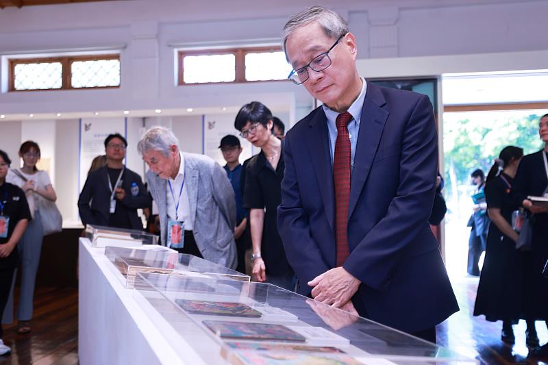 文化部長李遠（右1）仔細端詳現場陳列的漫畫，介紹從日治時期起，臺日少年漫畫文化彼此交織、相互影響的百年歷程。