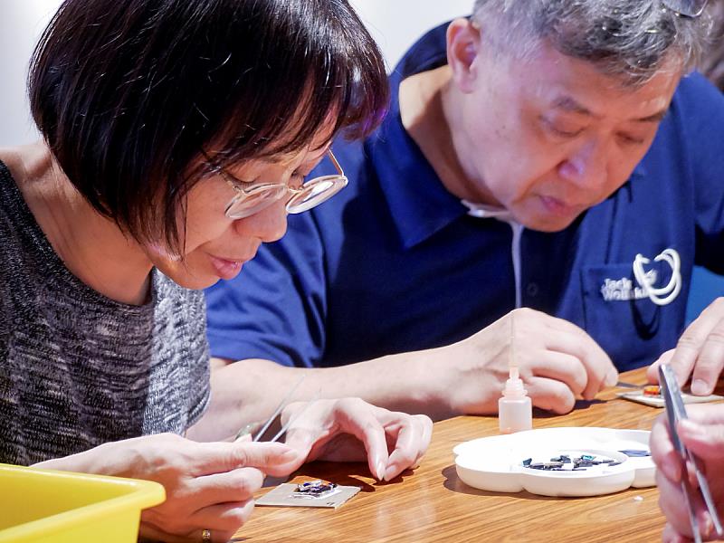 五彩玻璃片在桌上閃耀，大家專心拼貼，將靈感化為獨特的創作。