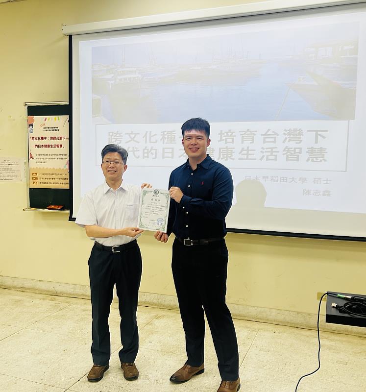 亞大幼教系傑出校友陳志鑫(左)，日前返校分享留學心得，由該系主任陳昇飛(左)頒發感謝狀給他。