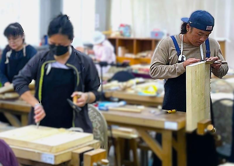 原民青年小宇參加北分署失業者職前訓練--細木作技術人才培訓班培訓跨領域技能，小宇(右)在課堂上課學習木工，結訓後成功進入文創公司擔任工藝師