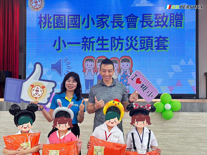 桃園國小家長會長王承偉致贈小一新生防災頭套，桃園國小校長與家長會長一起與新生合影。