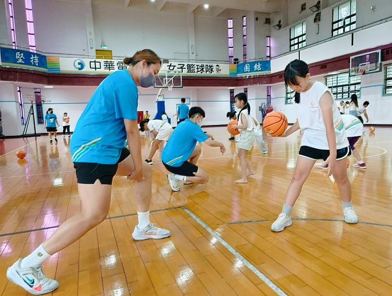 電信女籃親自示範胯下運球,學員全神貫注觀察每一個細節。