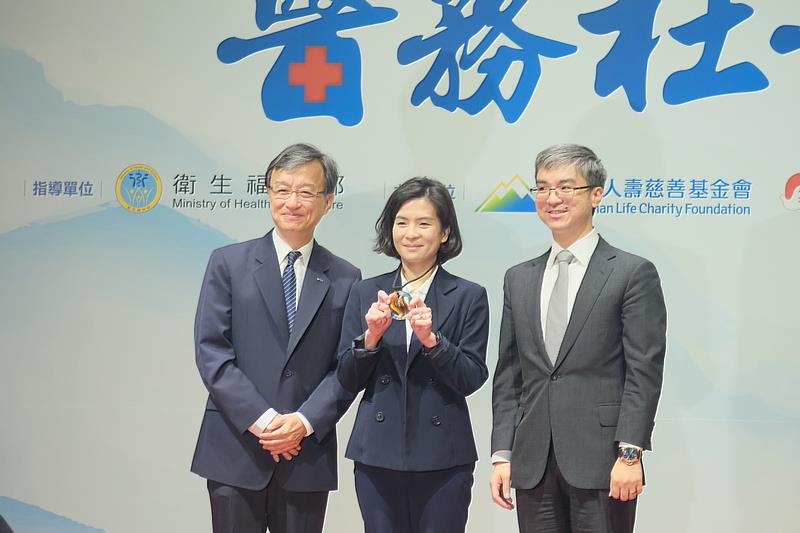 獲得第八屆南山醫務社工獎個人組卓越獎的社服室組長黃昱惠，十年長駐急診，致力於花蓮的兒少保護、性侵害和家暴的防治投入，備受評審團肯定，由花蓮慈院資深顧問李毅醫師陪同，從南山人壽慈善基金會董事長尹崇堯（右）手中接過專屬獎牌。(攝影/游濬紘)