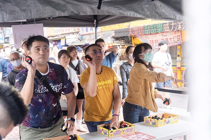 擲福大賽參賽者於福牆前投擲福球，爭奪象徵福運與榮耀的「百福大獎」。