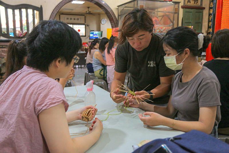 竹編藝師王藝霖（中）細心教導學員編製竹香包吊飾的技巧，讓學員從基礎學起，親手完成獨一無二的工藝作品。