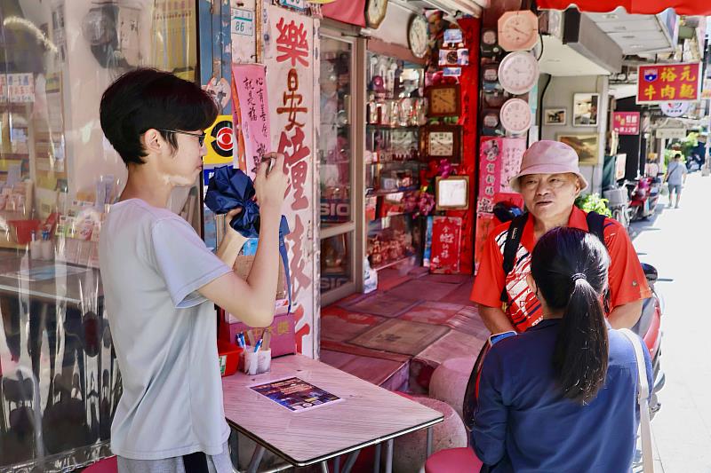 田野調查校外組「活化淡水老街」小組成員訪問當地居民，對於輕軌進入老街的看法。（圖／淡江大學提供）