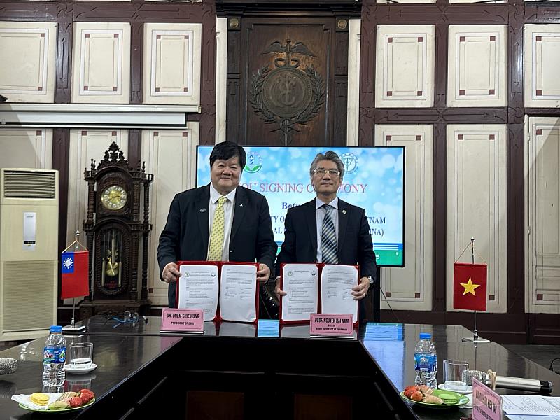 中國醫藥大學洪明奇校長(左)與越南河內藥科大學的Nguyen Hai Nam校長於續簽兩校的合作備忘錄後合影。