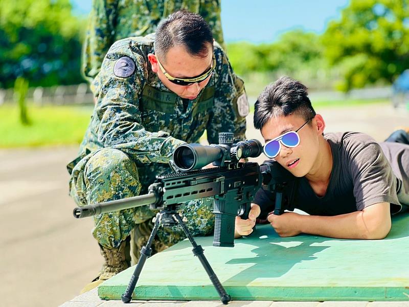 憲兵中隊長耐心指導,參與者聚精會神瞄準目標。