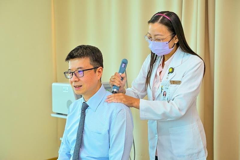 台灣人壽策略長葉栢宏體驗中山附醫智慧賦能中心「震波治療儀」。／台灣人壽提供