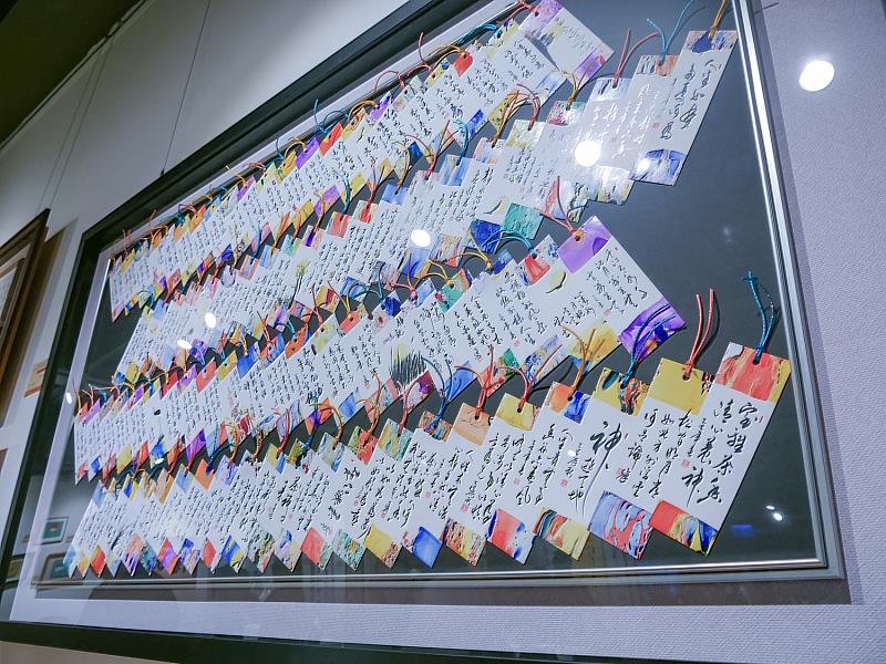 唐菁老師的創作手寫詩籤，一張張繽紛的詩籤整齊排列，每一幅都承載著祝福意涵，為觀眾帶來嶄新的藝術體驗。