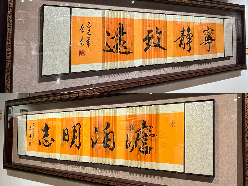 黃色書幅隨光線與角度流轉，字形在「寧靜致遠」「澹泊明志」之間交替呈現，展現唐菁老師「重影書法」的巧思，令觀者讚嘆不已。