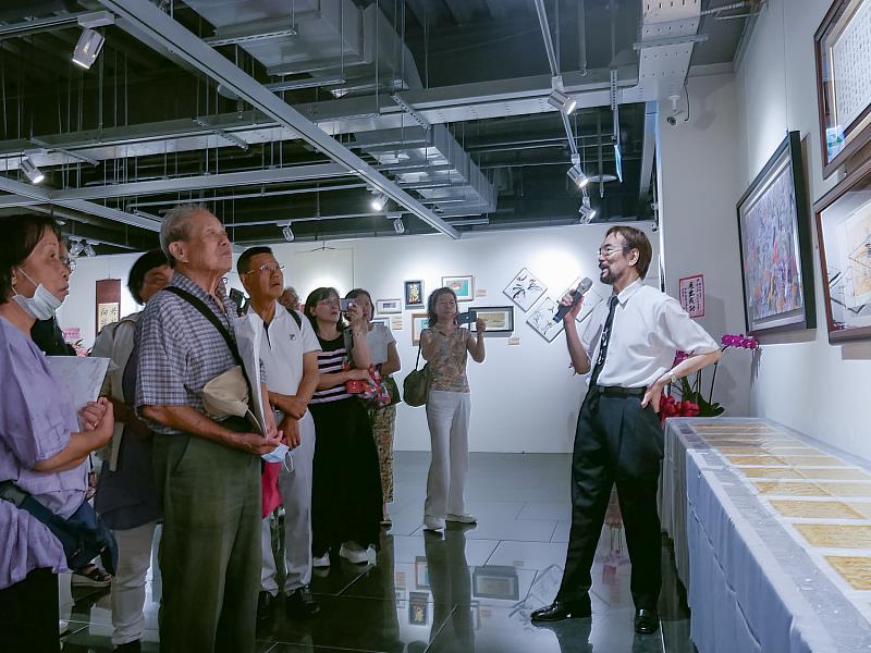 展覽開幕茶會上,唐菁老師親自為觀眾講解「重影書法」作品,現場來賓專注聆聽,沉浸於書藝創新的魅力之中。