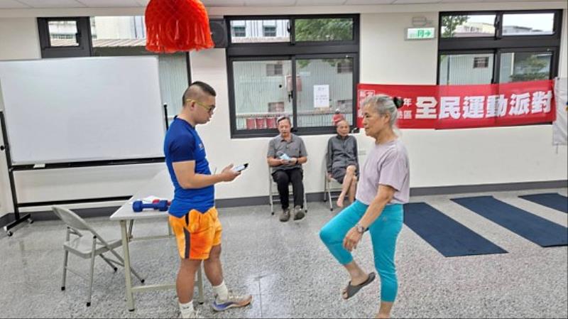 林本記T-SoX 飈動教練(藍色衣服)正在幫民眾做心肺體適能測試項目—原地踏步2分鐘，此為銀髮(65歲以上)體適能檢測項目，樹林場