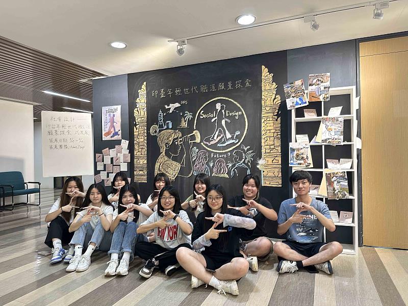 教設系學生所組成的策展團隊一起完成主題板畫,擺出團隊名稱「Next Ztep(下一步的Z世代)的「Z」手勢。(圖/淡江大學提供)