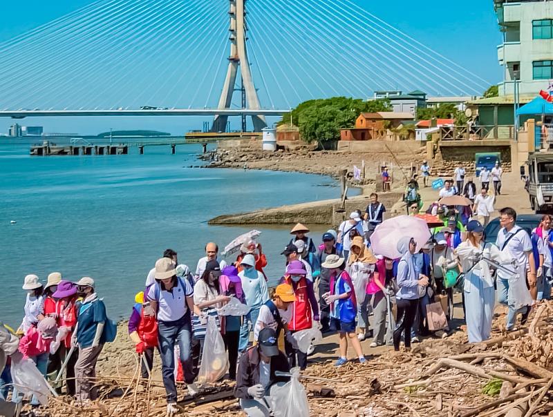 每個人手拿著垃圾袋與夾子，以行動守護淡水河生態環境，讓生態環境變得更加美好。（永慶房產集團提供）