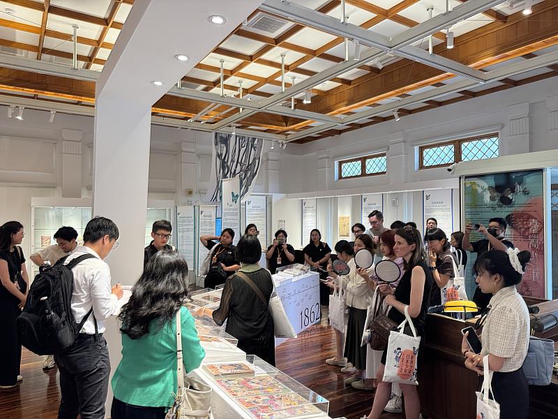 外賓們參觀國家漫畫博物館，由策展人李衣雲教授導覽「臺灣少年與日本少年—臺日漫畫．百年邂逅」國際交流展。（文策院提供）