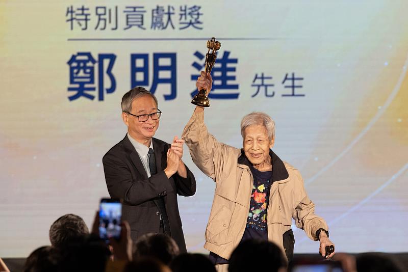 文化部長李遠（左）代表正在花蓮勘災的行政院長卓榮泰頒發特別貢獻獎予鄭明進（右），所有出版界後進給予最熱烈的掌聲及喝采。