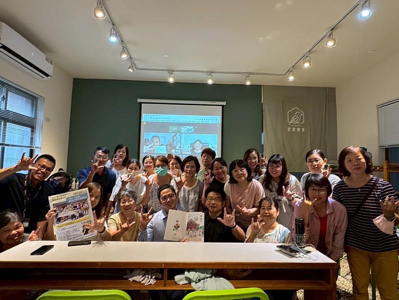 國立新竹生活美學館館長葉于正(第一排中右)、張哲維教授(第一排中左)及與現場參與者共同以手語「我愛你」合照,手中所持為本期巢兼代季刊。