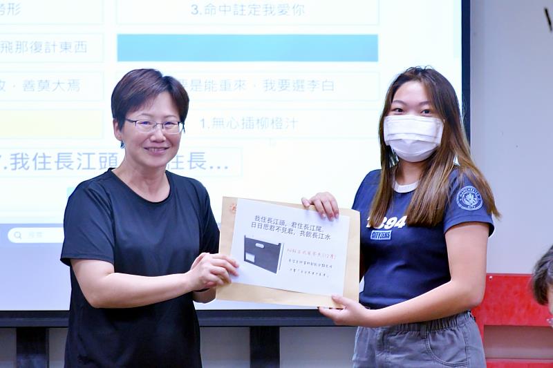 南華大學文學系感謝師恩，以創意逗趣表心意，江江明助理教授（左）獲學生頒贈「女力全開獎」。