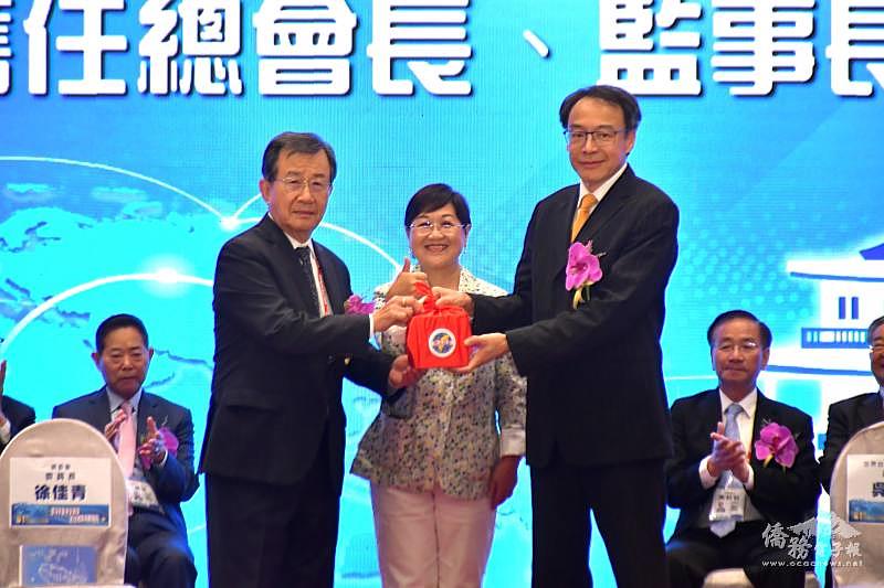僑務委員會委員長徐佳青（中）監交世總第31屆總會長吳光宜（左）將印信交給世總第32屆總會長熊強生（右）