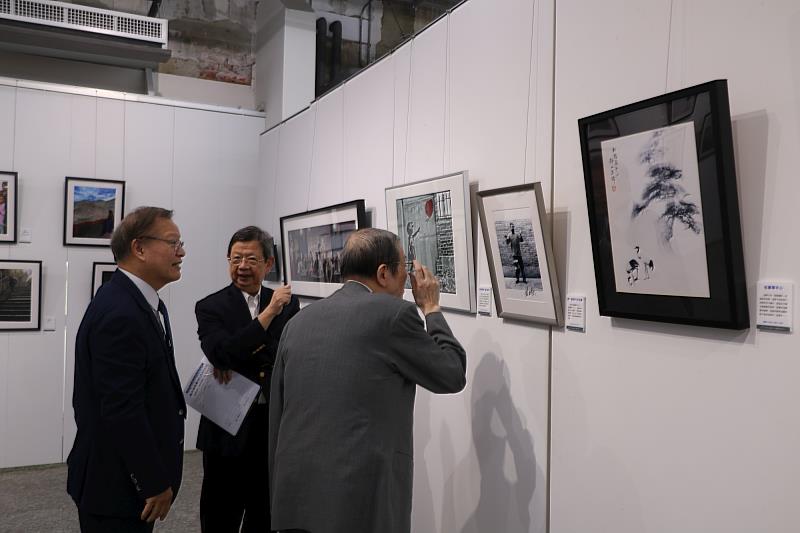 江安世校長、黃榮村前考試院長仔細端詳體會攝影作品。