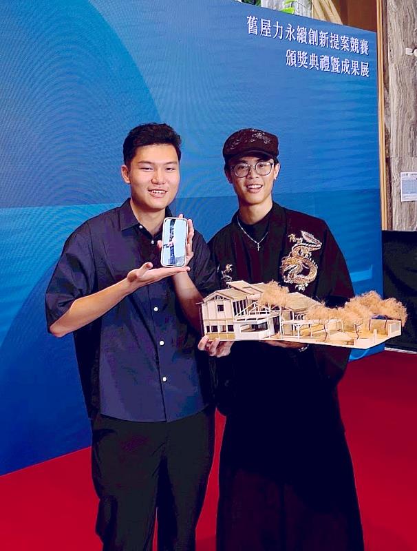 南華大學建築系榮獲學生組創新設計首獎，獲獎學生徐瀚佐（右）、陳亮宇（左）、周承雋（手機中）與獲獎作品合影。