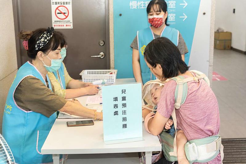 衛生所同仁協助民眾量體溫、報到等作業。