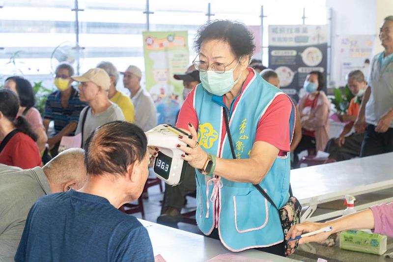 衛生所同仁協助民眾量體溫、報到等作業。