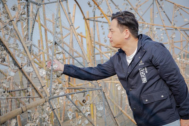 邱臣遠代理市長參觀藝術家李蕢至以竹材與蚵殼打造的裝置藝術《潮與巢Tide and Nest》，並親手固定蚵殼。