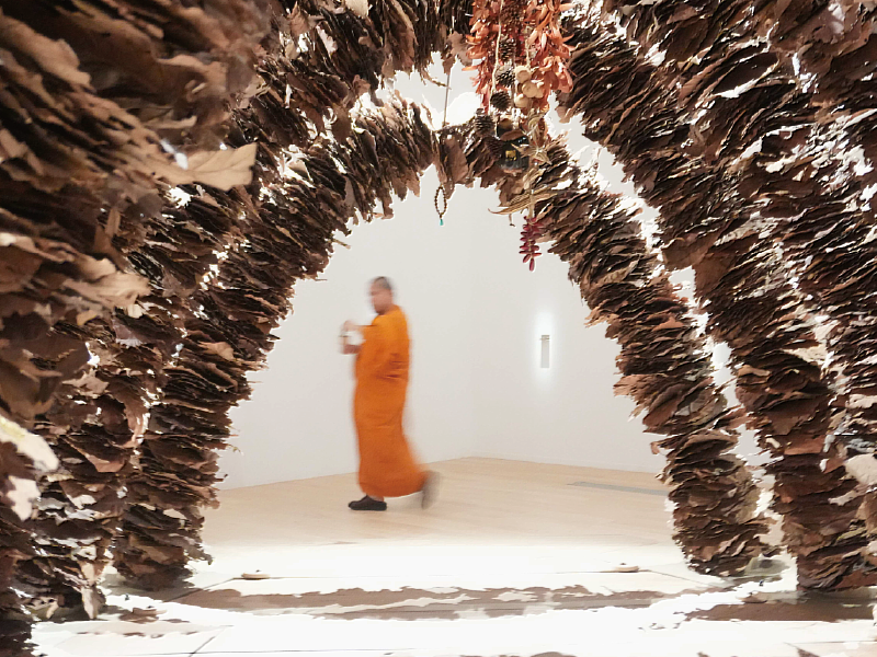 泰國僧侶於藝術家布恩森．普瑞姆塔達（Boonserm PREMTHADA）作品〈藥草之廟〉前進行祈福儀式。（攝影：鍾惠淳，新北市美術館提供）