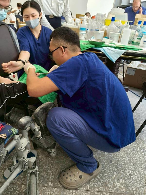 花蓮慈院骨科陳林睦醫師現場半跪半蹲著為傷患縫合傷口。累計至10月2日晚上8點半，花蓮慈濟醫院醫療隊動員562人次，光是外科醫療人次就已經突破千人，10天下來的醫療診治人次達2,663人。