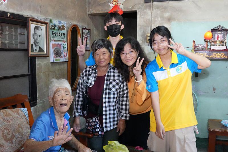 計畫主持人陳美珠副教授（右2），與計畫學生走訪100歲獨居長輩（左1），邀請前來參與市集活動。