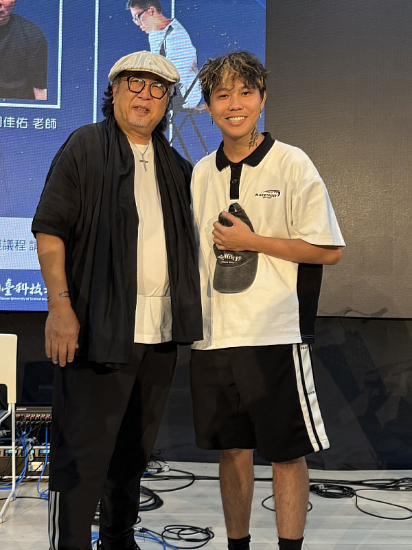 流行音樂產業系馬來西亞學生陳俊桉與亞洲流行音樂教父鮑比達老師會後合影。陳同學表示，鮑比達老師對華語音樂圈的觀察，啟發他要勇於讓自己的文化被聽見。