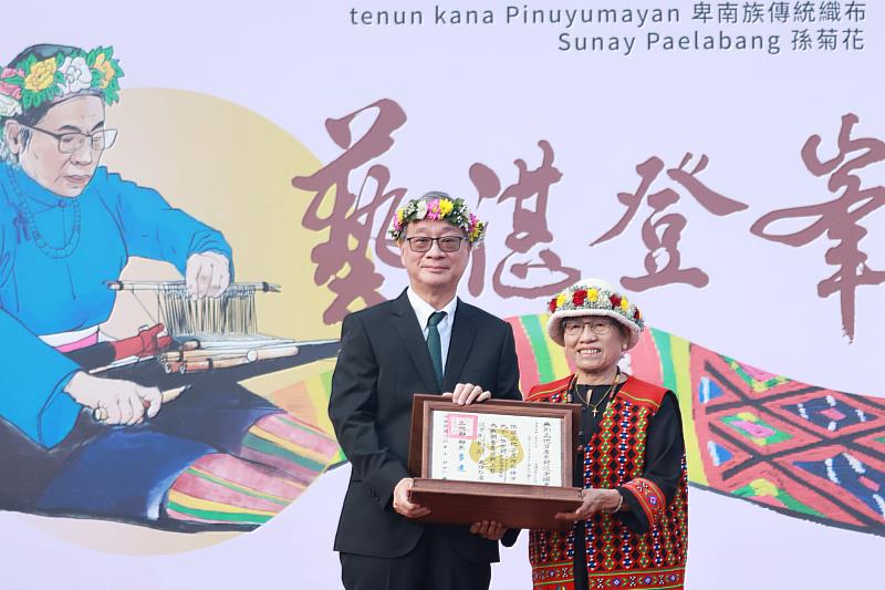 文化部長李遠（左）頒授認定證書予「tenun kana Pinuyumayan卑南族傳統織布」保存者Sunay Paelabang孫菊花，表彰其於「tenun kana Pinuyumayan卑南族傳統織布」的成就。
