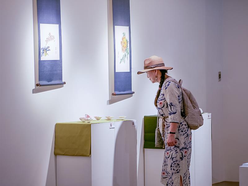 觀眾駐足欣賞展覽作品，漫步展場之間，感受陶與光影交織的細膩氛圍，靜靜體會藝術的溫度。