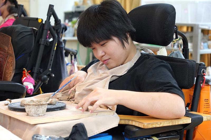 院生「橘子」為重度腦性麻痺患者，儘管雙手難以用力塑形，她仍以左手細捏造型筷架
