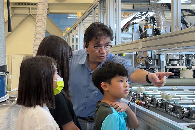 學童於鴻躉公司現場觀察太陽能板拆解機台運作,感受綠能科技的轉化力量。