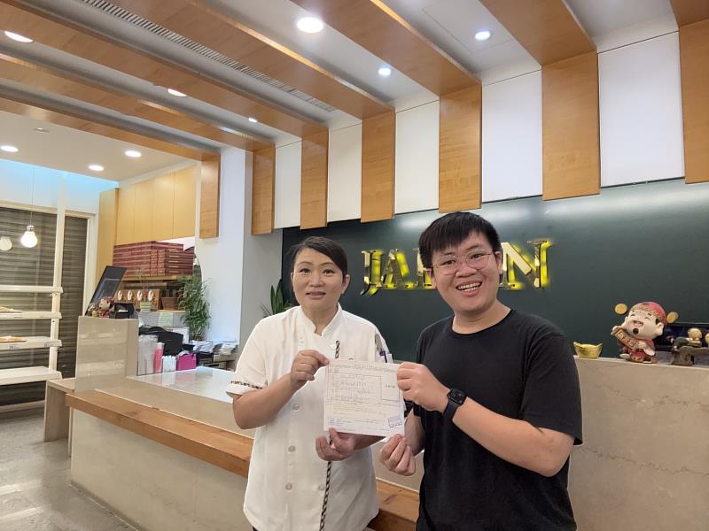 「暖暖堡」團隊成員陳柏翰(右)向店長蔡雅淇(左)遞交捐款證明