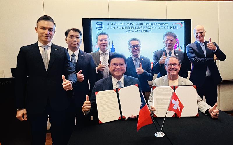 IEAT副理事長許介立(左)與KMU SWISS CEO, Armin Baumann(右)代表簽署MOU,駐瑞士代表處王思為代表(右3)、KMU SWISS President, Stefan Schaltter(右1)及IEAT理監事團員們見證
